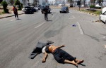 A body is seen on a street at a military encampment in central Tripoli